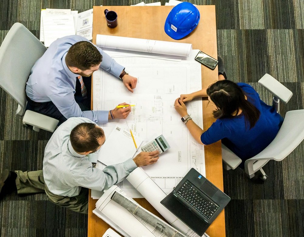 Three Engineers Sitting Beside Table